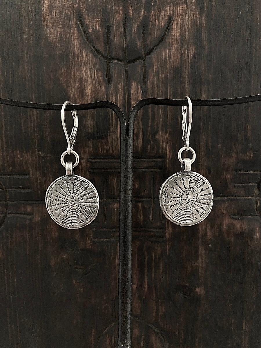 Many believe that a web protects by catching negativity before it affects you. We've etched our web on aged 925 sterling silver circle earrings.