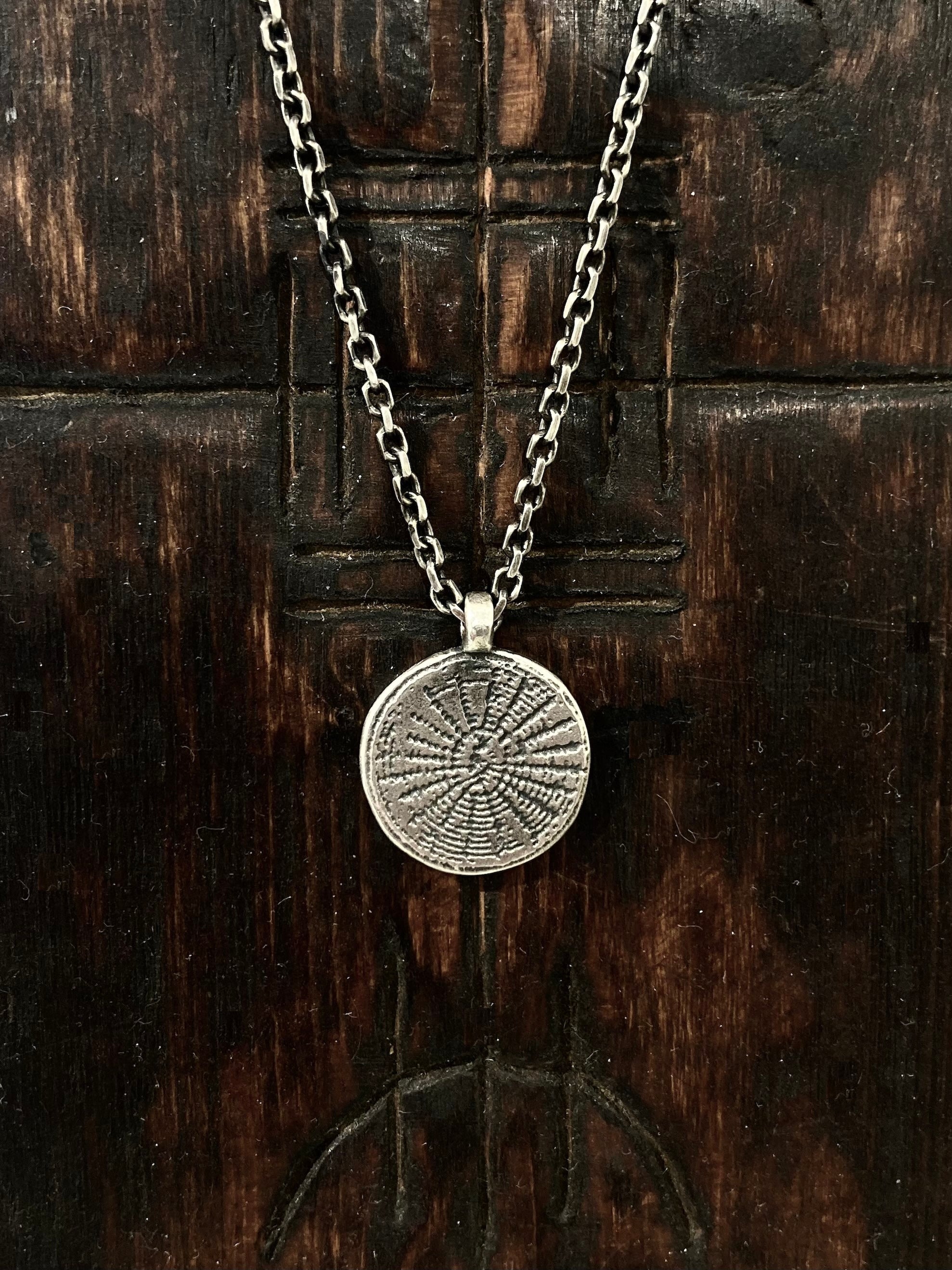 Many believe that a web protects by catching negativity before it affects you. We've etched our web onto an aged 925 sterling silver circle pendant.