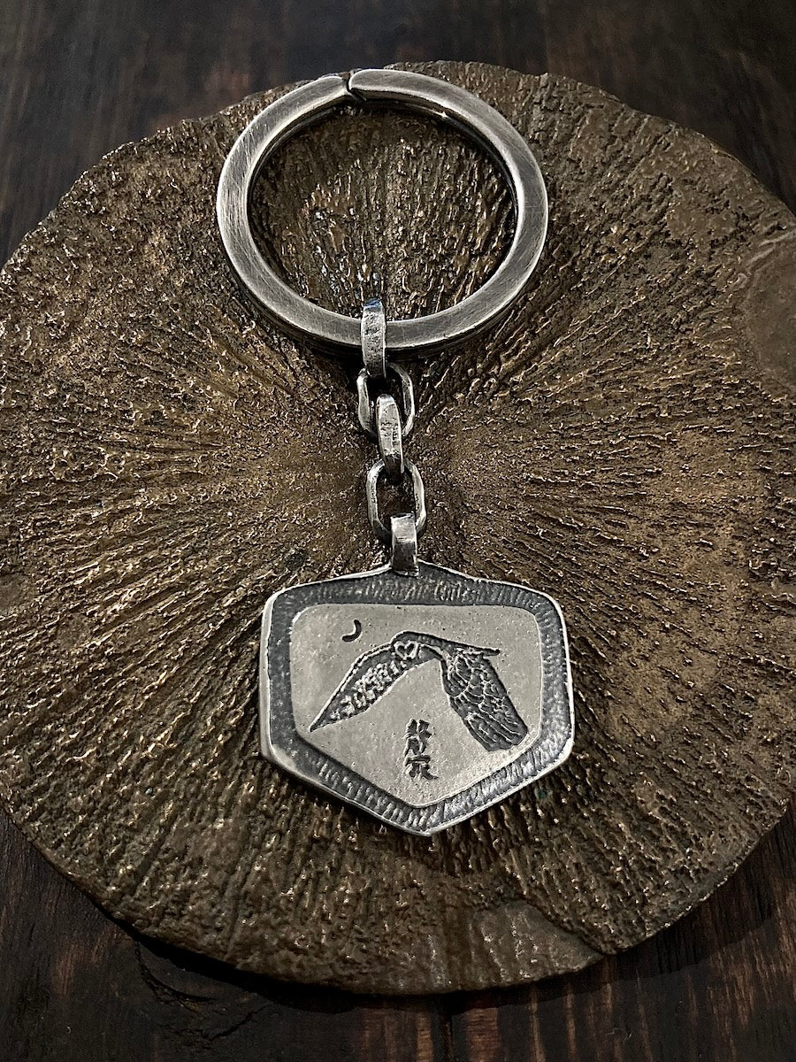 A handmade sterling silver keyring with a pendant featuring an owl design,