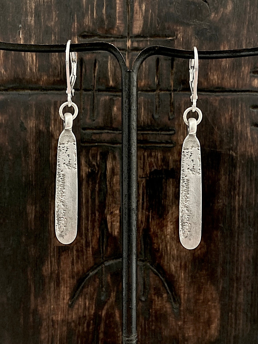 A pair of handmade sterling silver drop earrings with a textured surface mens jewelry womens jewelry