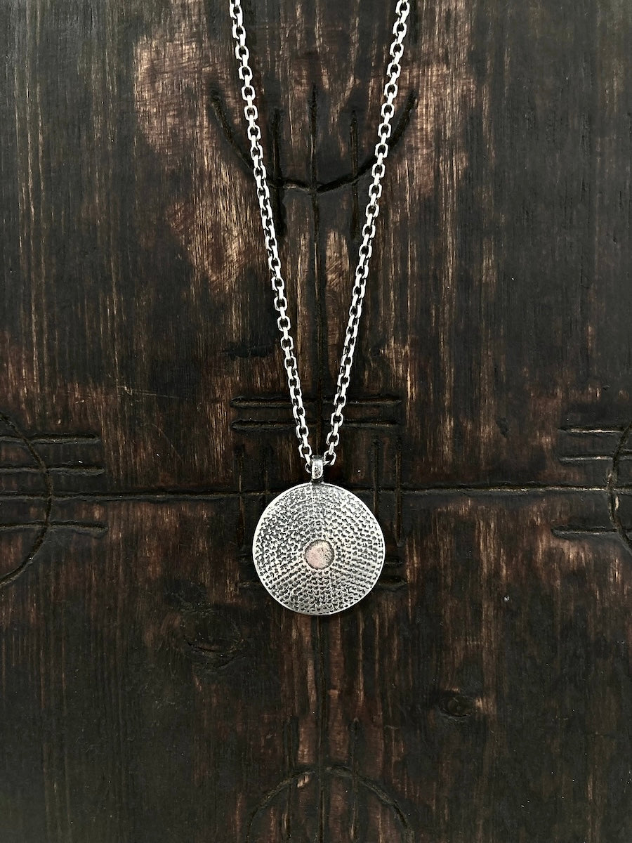 A handcast aged sterling silver domed shield pendant necklace with texture