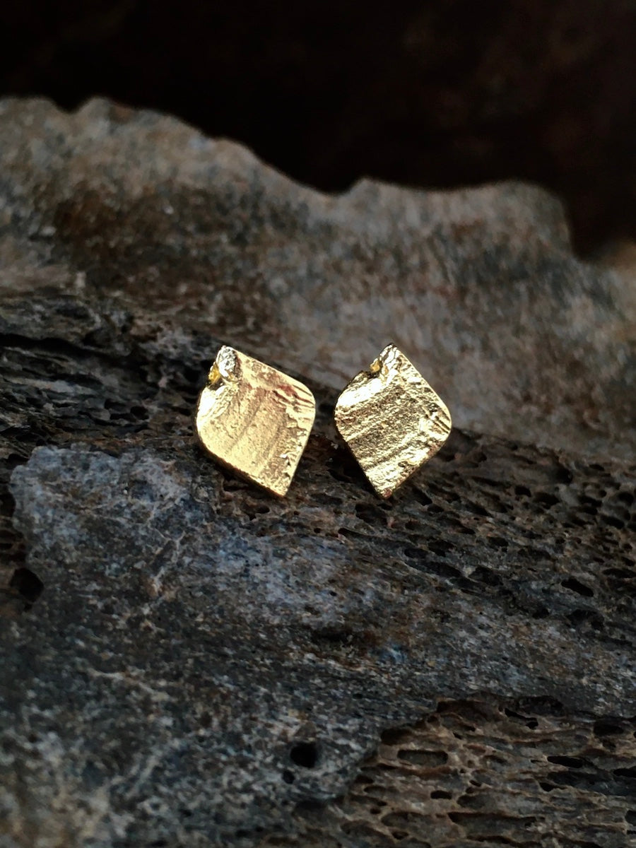 A pair of handmade textured leaf shaped stud earrings made of aged 14k solid gold mens jewelry womens jewelry