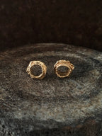 A pair of handmade 14k gold circle stud earrings inspired by spiritual vortex