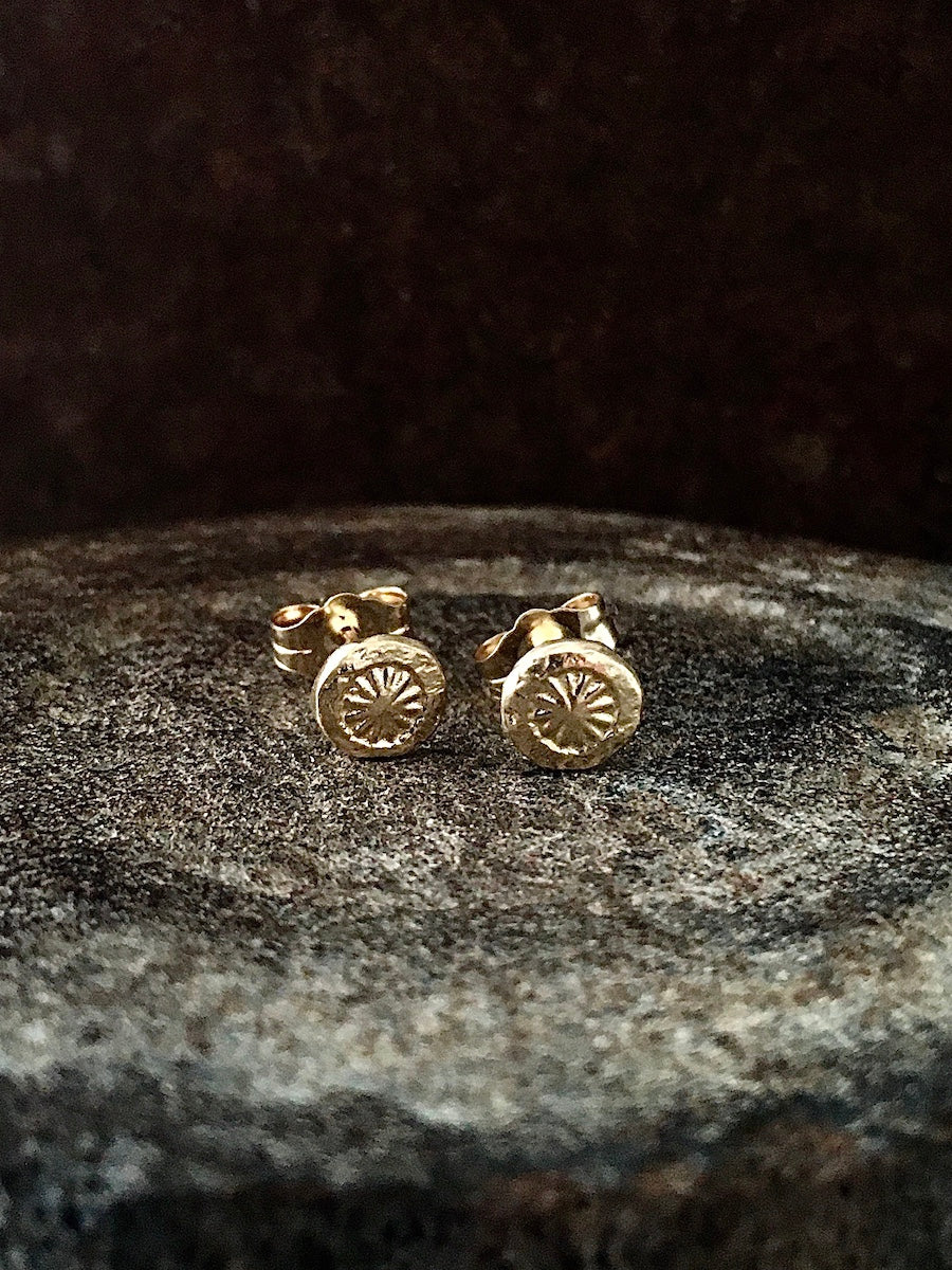 A pair of sterling silver stud earrings featuring a starburst design within a circle, Mens Jewelry Womens Jewelry